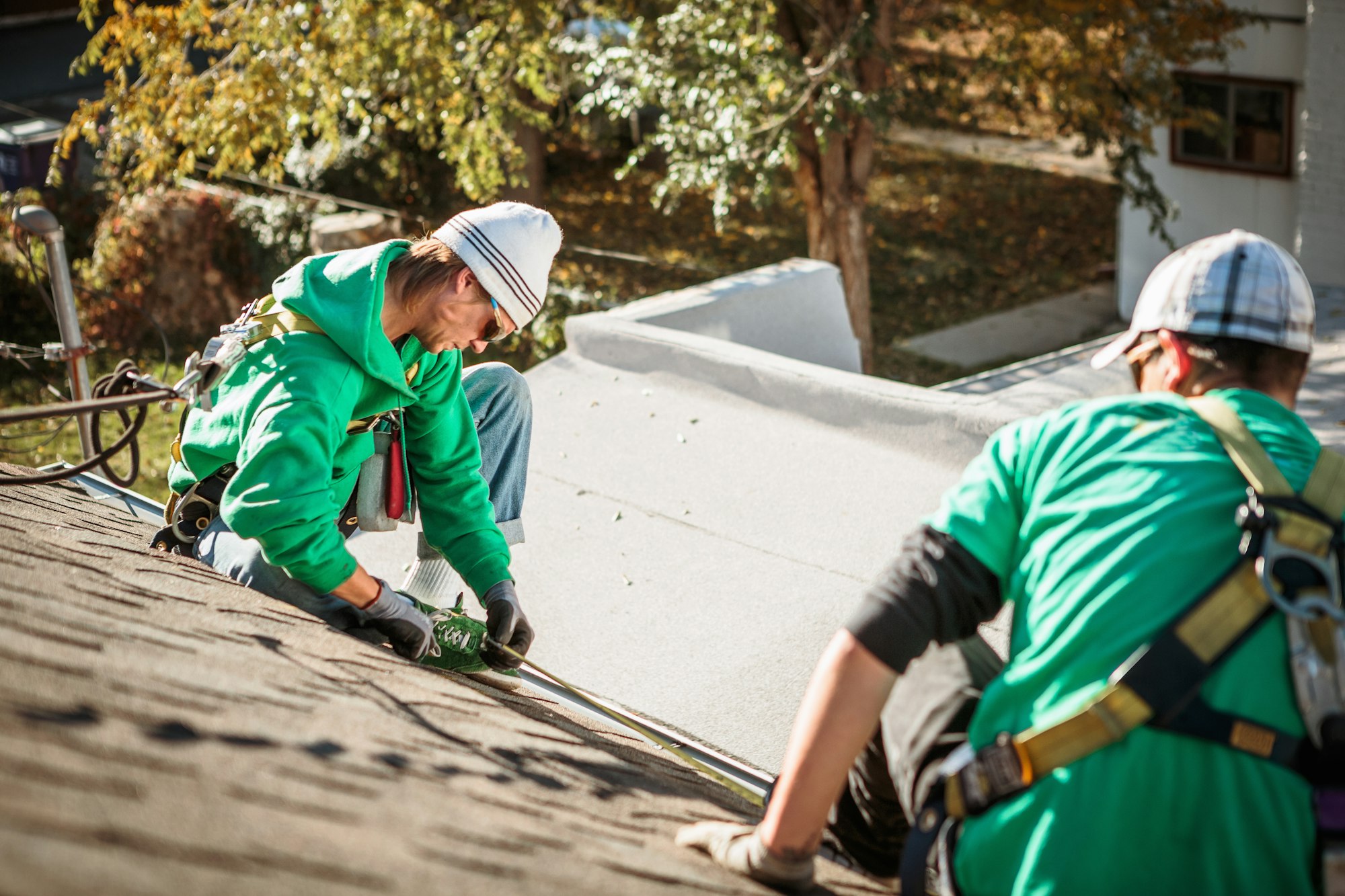 Solar panel installation crew members on roof of house